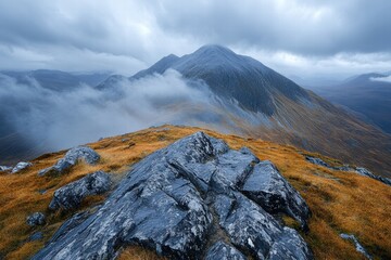 Wall Mural - A wide-angle view of a cloudy sky over a mountain range, with soft mist and fog rolling over the peaks