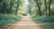 © egavirgian art - A blurry image of a winding park trail surrounded by soft, verdant greenery