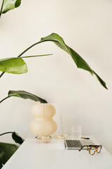 Wall Mural - inspiring workspace with laptop, retro glasses, and creative lamp on desk adorned with green plants