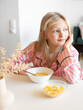 © Mariya Surmacheva - girl eating cornflakes with milk for breakfast, american breakfast
