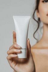 Wall Mural - beautiful beauty female woman's model hand holding white empty blank mockup skincare cream tube temp