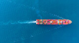 Top view Cargo Container ship with contrail in the ocean ship carrying container and running for import export concept technology freight shipping by ship.