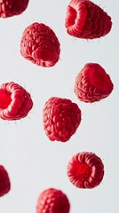 Aufkleber - Several ripe, red raspberries levitate against a clean white backdrop, creating a visually appealing and simple composition that emphasizes the natural beauty and vibrant color of the fruit