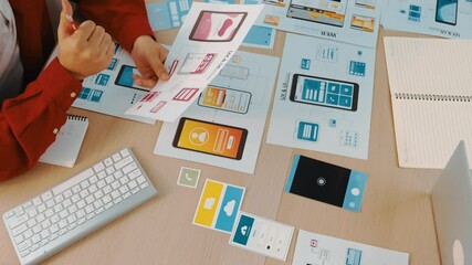 Poster - Hand focus of startup company employee present user interface prototype for mobile application to smart co-worker in office workspace. UX UI designer praise function of icon design on paper. Synergic