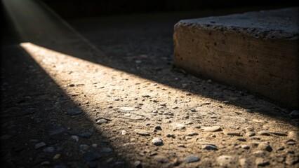 Aufkleber - A closeup captures the interplay of light and shadow over a rough concrete patch where a single beam of light interacts with a protruding piece of aggregate creating a vivid