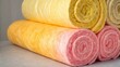 © DigitalSpace - A medium closeup of a stack of insulation rolls displaying soft fibrous texture and bright colors that underscore their importance in energy efficiency and comfort in building