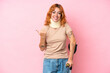 © luismolinero - Young caucasian woman wearing neck brace isolated on pink background pointing to the side to present a product