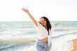 © morrowlight - Happy young adult woman 30-35 year old having fun over sea at beach outdoor. Summer time. Vacation season.
