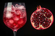 © stanhert - A pomegranate cut in half next to a glass of pomegrate juice
