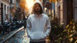 © abir - Handsome young man in a white sweatshirt with a hood standing on the stree