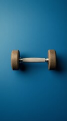Poster - Wooden dumbbell with a metal grip lies horizontally on a solid blue backdrop, symbolizing a commitment to exercise, strength training, and a healthy lifestyle