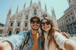 © Sean Hoong - A pair of happy tourists in front of Milanâ€™s Duomo Cathedral, taking a selfie on a bright summer day, enjoying their Italian adventure. =
