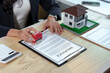 © Phimwilai - Real estate agent stamping an insurance policy document for a new house, providing essential safety and financial protection for homeowners during the purchasing process