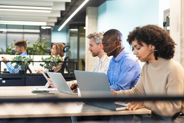 Wall Mural - Attractive positive young businesspeople and colleagues in a call center office.