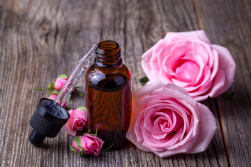 Wall Mural - Bottles of essential rose oil and flowers