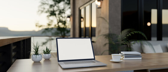 Wall Mural - A laptop with a white screen mockup on a wooden table on a cozy contemporary home balcony.