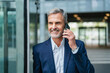 © Westend61 - Smiling gray haired businessman talking on smart phone