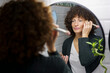 © Westend61 - Woman with curly hair applying make-up in bathroom at home