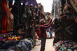 © Westend61 - Smiling tourist selecting shawls at market