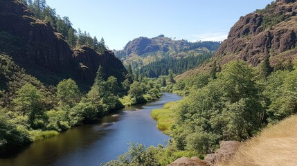 Sticker - Serene river flowing through a lush green valley surrounded by steep, rocky mountains under a clear blue sky.