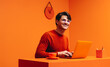 © Jacob Lund - Smiling man working on laptop in a vibrant monochromatic orange office setting