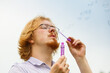 © Voyagerix - Man blowing soap bubbles, having fun