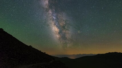 Wall Mural - Time Lapse Lockdown Shot Of Milky Way Stars Moving In Sky Over Silhouette Mountains At Night - Big Pine, California