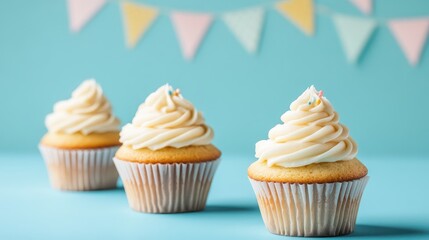 Poster - Vanilla cupcakes with creamy frosting on blue background perfect for bakery promotional use with copy space for advertising