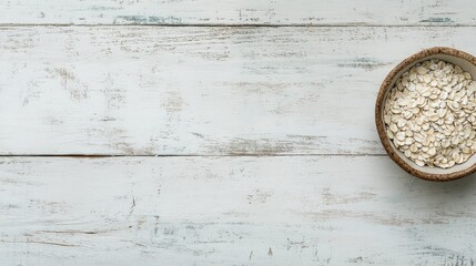 Poster - Bowl of raw rolled oats on rustic white wooden table with empty space for healthy breakfast or recipe text placement