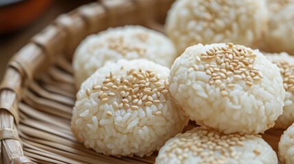 Aufkleber - Delightful close-up of traditional rice cakes garnished with sesame seeds arranged in a woven basket on a rustic wooden table