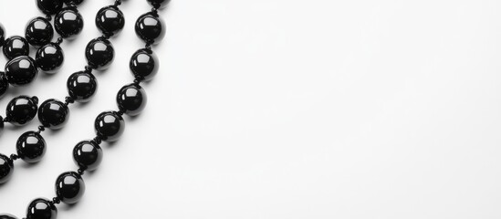 Aufkleber - Elegant black smooth beads arranged on a white background with ample blank space for text or design elements. Ideal for jewelry marketing.