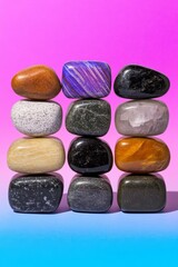 Wall Mural - Colorful polished stones stacked on a gradient background, representing balance and harmony, perfect for wellness and meditation concepts