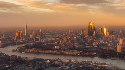 Wall Mural - Time lapse view of the urban skyline of London, England, with City skyscrapers and River Thames during a golden winter sunrise