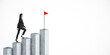 © Who is Danny - Woman climbing steps towards red flag on abstract background, symbolizing success and goal achievement.