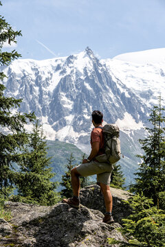 Mountaineering man with backpack contemplating the mountains from the top of Montblanc