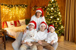 © Tomsickova - Happy family on Christmas, enjoying some quality time together, kids and adults with pet dog on Christmas eve