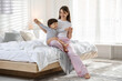 © New Africa - Happy mother playing with her little son in bedroom