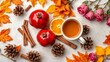 © Surangkanang - Autumn themed flat lay composition featuring a cup of tea, dry leaves, roses, flowers, cones, pomegranate, cinnamon sticks on a brown beige background, pomegranate, cones, flat lay