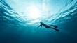 © musa - Underwater silhouette of a person freediving.