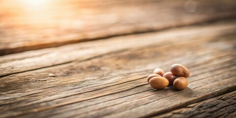 Poster - Rustic Wooden Surface with a Small Pile of Brown Nuts in Warm Lighting