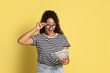 © New Africa - Shocked woman with dollar banknotes on yellow background