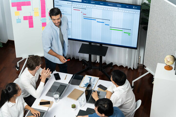 Leinwandbilder - Project manager communicate and collaborate with team using project management software display on monitor, tracking progress of project task and making schedule plan at meeting table. Prudent