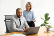 © New Africa - Coworkers with laptop working together in office