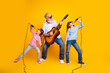 © deagreez - Happy family bonding with music on yellow backdrop showcasing joy and togetherness