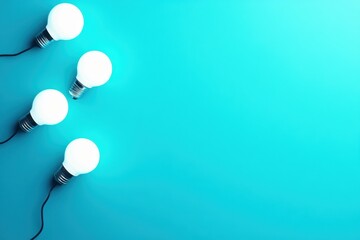 Poster - Four glowing light bulbs on a bright turquoise background create a fresh and modern atmosphere.