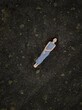 © Milou Dirks - art portrait of asian girl in long blue dress laying on black lava beach in Iceland with view from drone