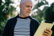 © BullRun - Concentrated aged male surfing tablet in park