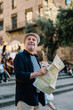 © BullRun - Positive senior traveler with map of city