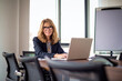 © gzorgz - A middle-aged woman with blonde hair is sitting in the office working