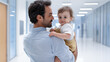 © Kiangdeb - A loving father holds his smiling baby in a bright hallway, capturing a moment of connection and warmth